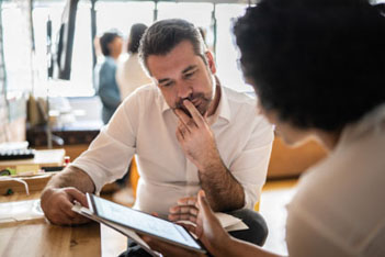 Man and woman reviewing information on a tablet