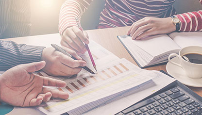 Hands positioned over charts and diagrams on a table